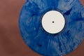 A mottled blue vinyl record with a white centre sticker