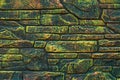 Mottled painted stone wall. Fluorescent paint on rock background. Green and yellow texture in modern style. Brick wall backgrounds Royalty Free Stock Photo