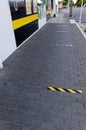 Yellow and black tape on the pavement to show where to stand to