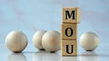MOU- acronym on wooden cubes on the background of light balls Royalty Free Stock Photo