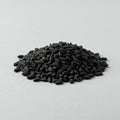 A mound of black seeds is displayed on a plain white surface. The seeds are small, Royalty Free Stock Photo