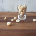 A mound of organic Macademia nuts on a rustic wooden table