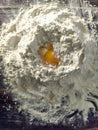 A mound of wheat flour with a broken chicken egg inside. View from above Royalty Free Stock Photo