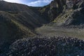 Mounds of stones and rock piles, with rocky outcrops, in a disused quarry, blue sky with clouds