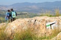 Mount Arbel touristic stony route for hiking. Man and woman travelers with backpacks  study route map Royalty Free Stock Photo