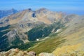 View from the top of Nub Peak. Beautiful landscape, grey and brown mountains, green forest, blue sky.