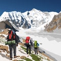 Mount Cho Oyu and three hikers with a big backpack