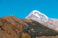 Mount Kazbek Mkinvartsveri and Gergeti church at sunny day. Caucasus mountains Royalty Free Stock Photo