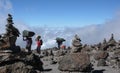 Mount Kilimanjaro / Tanzania: 5 January 2016: porters carry equipment and material through a rock desert with many stone cairns on