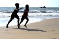 Mount Lavinia Beach. Colombo, Sri Lanka. 05th March 2016. Silhouette of  two boys enjoying running at the beach with the sunrise b Royalty Free Stock Photo