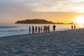 Group of young people standing at waters edge waiting to enter at sunrise