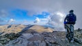 Mount Olympus - Man with helmet sitting on cloud covered mountain summit of Skolio peak on Mount Olympus