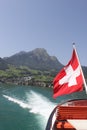 Mount Pilatus with Swiss Flag and wake of boat.
