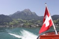 Mount Pilatus with Swiss Flag and wake of boat.