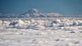 Mount Rainier covered with snow and ice above clouds. Royalty Free Stock Photo