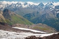 Mount Terskol observatory, Caucasus, Russia - August, 2019: white dome and other buildings on green slopes among snowy mountains.