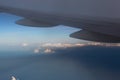 Mountain and airplane wing landscape viewed from aircraft window with white cloud and golden sunlight Royalty Free Stock Photo