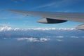 Mountain and airplane wing landscape viewed from aircraft window with white cloud and golden sunlight Royalty Free Stock Photo