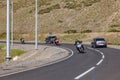 Mountain asphalt road in Altai with three motorbikes and bikers in helmets moving one after another in one direction and two cars Royalty Free Stock Photo