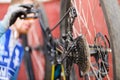 Mountain bicycle repairing. MTB rear wheel with disk brakes closeup and mechanic at work in background Royalty Free Stock Photo