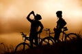 Mountain bike couple drinking in silhouette Royalty Free Stock Photo