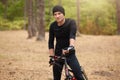 Mountain bike cyclist riding single track outdoor with trees on background, attractive male wearing black sport clothing and cap Royalty Free Stock Photo