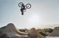 Mountain bike jump training man on rocks hill cycling in air, blue sky mockup for professional performance, training or Royalty Free Stock Photo