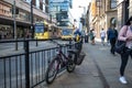 Mountain bike locked to metal railing in a busy street with tram and bus public transport in the background