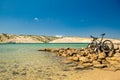 Mountain bike over sea, mountains and blue sky on a rocky beach Royalty Free Stock Photo