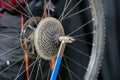 mountain bike repair. Bike mechanic in the workshop. Replacement of the rear wheel cassette. Dirty wheel, hub and spokes and worn Royalty Free Stock Photo