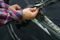 Mountain bike repair in the workshop. Mechanic's hands and tool close-up. The mechanic cuts off the old cable. A