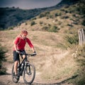 Mountain bike rider on country road, track trail in inspirational landscape Royalty Free Stock Photo