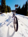 Mountain bike standing in frozen snow against blue sky. Hidden asphalt road Royalty Free Stock Photo