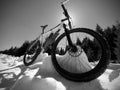 Mountain bike standing in frozen snow against blue sky. Hidden asphalt road Royalty Free Stock Photo