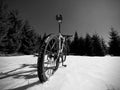 Mountain bike standing in frozen snow against blue sky. Hidden asphalt road Royalty Free Stock Photo