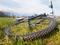 Mountain bike wheel close up. Mtb lying on the grass of alpine meadow. Wide angle view Royalty Free Stock Photo