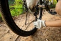 Biker fixing the bike chain on forest trail