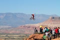 Mountain biker jumps cliff and crowd watches