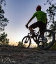 Mountain biker looking at sunset, bike trail in autumn mountains Royalty Free Stock Photo