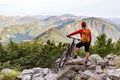 Mountain biker looking at view on bike trail in autumn mountains