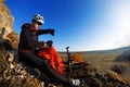 Mountain biker looking at view on bike trail in spring landscape. Male rider resting on cycling trip in nature. Royalty Free Stock Photo