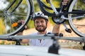 mountain biker man takes bike from car roof Royalty Free Stock Photo