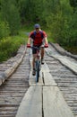 Mountain biker on old wooden bridge Royalty Free Stock Photo