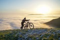 Mountain Biker Pushing Bike Up to the Mountain Above the Clouds Royalty Free Stock Photo