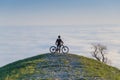 Mountain Biker Reaching Summit Above the Clouds Royalty Free Stock Photo