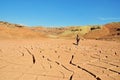 Mountain biker riding bike in cracked land of dry desert