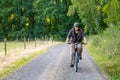 Mountain biker riding on bike in summer forest landscape. Active middle-aged man cycling on bicycle, sports and leisure Royalty Free Stock Photo