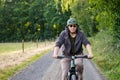 Mountain biker riding on bike in summer forest landscape. Active middle-aged man cycling on bicycle, sports and leisure Royalty Free Stock Photo