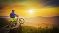 Mountain biker riding at sunset on bike in summer mountains fore