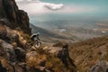 mountain biker scaling steep and rocky terrain, with view of sprawling landscape in the background